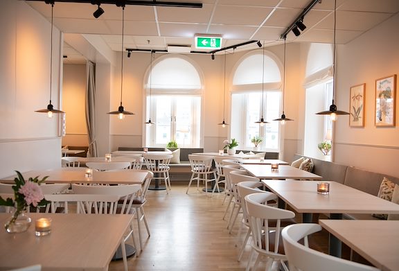 Canteen with white furniture and large windows. Photo.